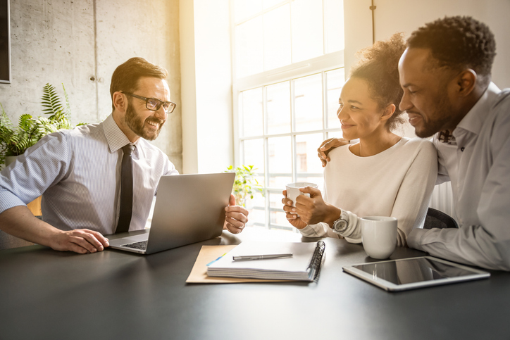 A young couple meets with their financial advisor to create an investment plan for retirement. 